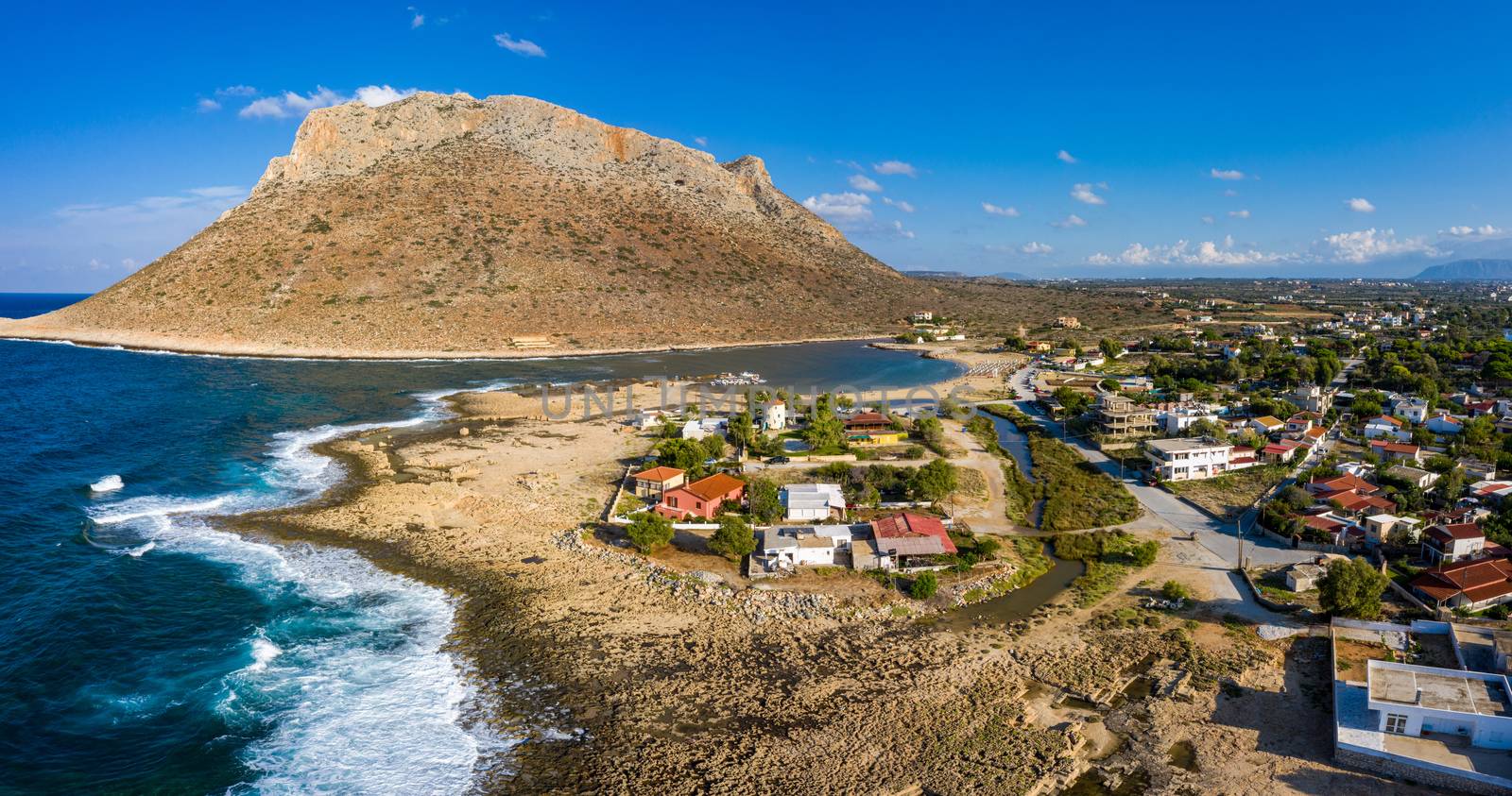Aerial drone top view of turquoise organised beach forming a small heart shaped lagoon and mountainous seascape of Stavros, Chania, Crete island, Greece. Picturesque Stavros beach at Crete, Greece.