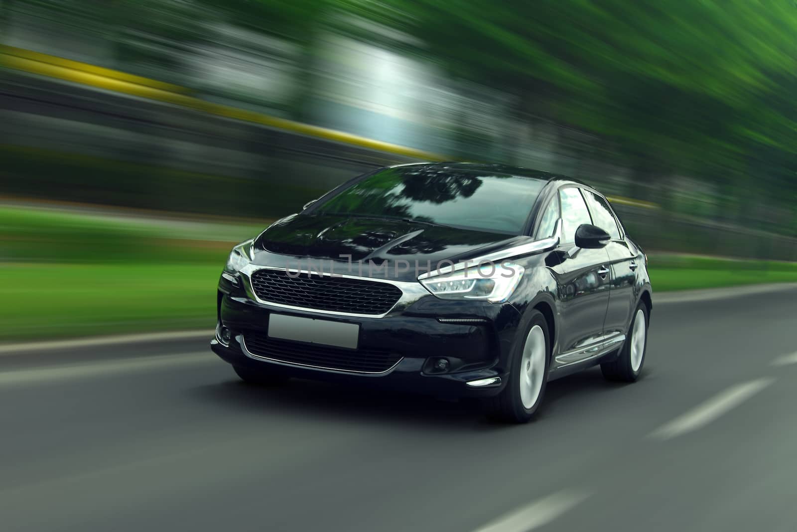 A panning shot of a speeding black car