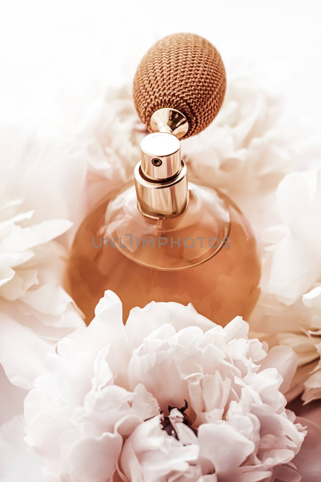 Fragrance bottle as vintage perfume product on background of peony flowers, parfum ad and beauty branding design