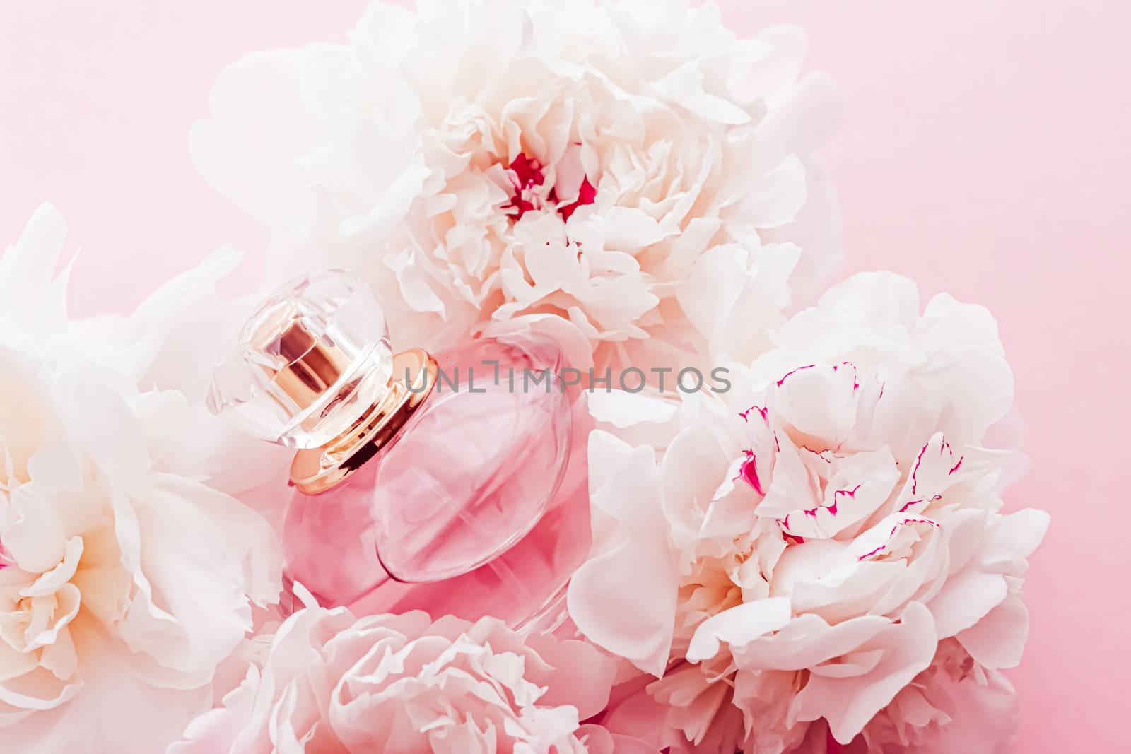 Luxe fragrance bottle as girly perfume product on background of peony flowers, parfum ad and beauty branding design