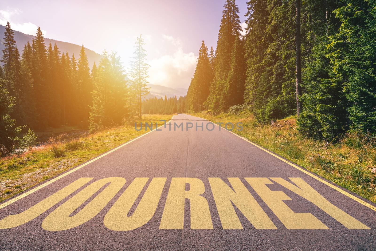 Journey word written on road in the mountains. Journey text on the road.