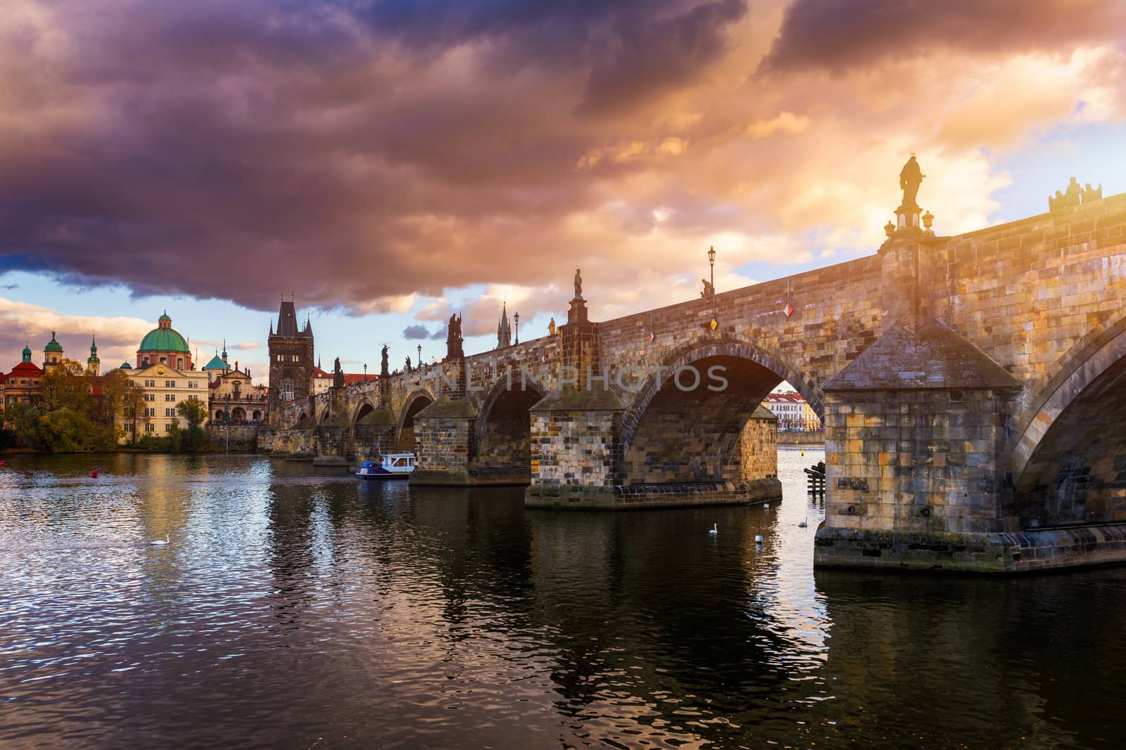 Autumn view to Charles bridge on Vltava river in Prague, Czech Republic. Autumn view to Charles Bridge, Prague old town and Vltava river. Czechia. Scenic autumn view of the Old Town with red foliage.