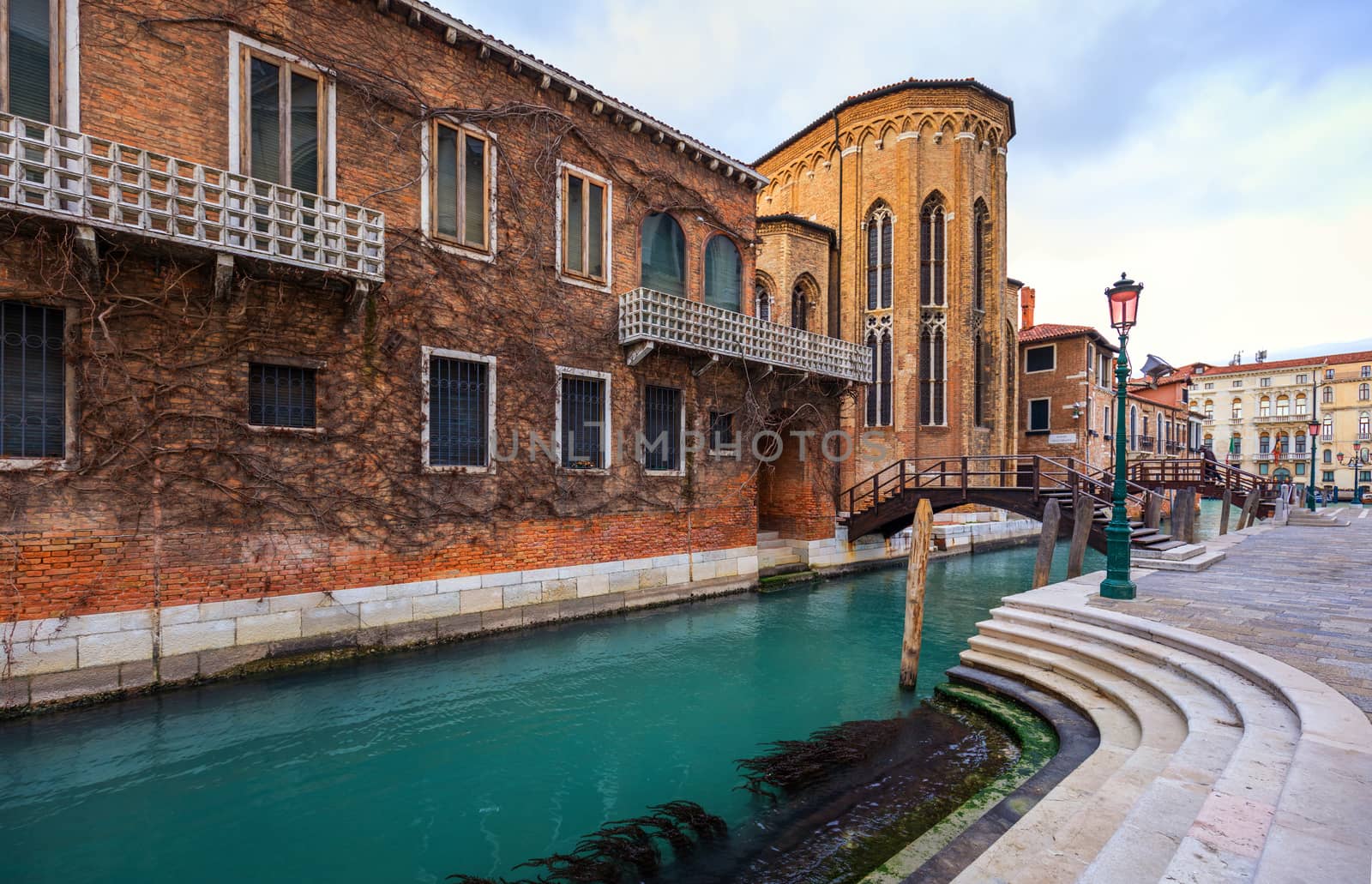 Street canal in Venice, Italy. Narrow canal among old colorful brick houses in Venice, Italy. Venice postcard