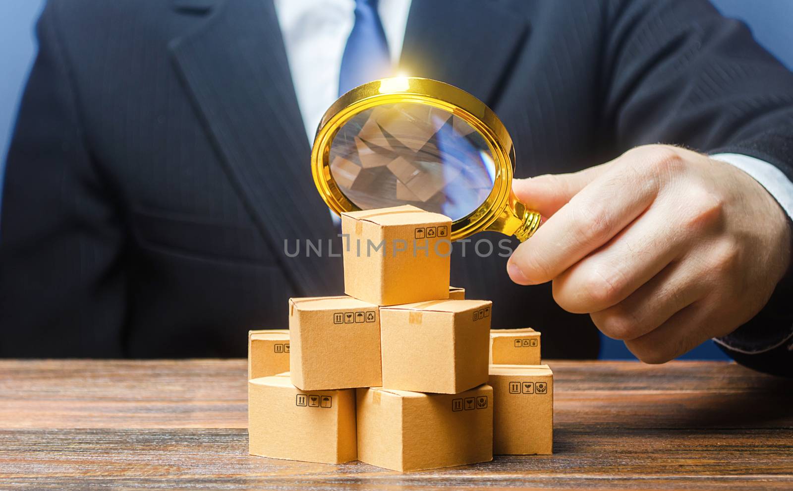 Businessman examines boxes goods with magnifying glass. Marketing sales promotion strategy. Trade market structure research, find unoccupied target consumer niches. Quality control and standards