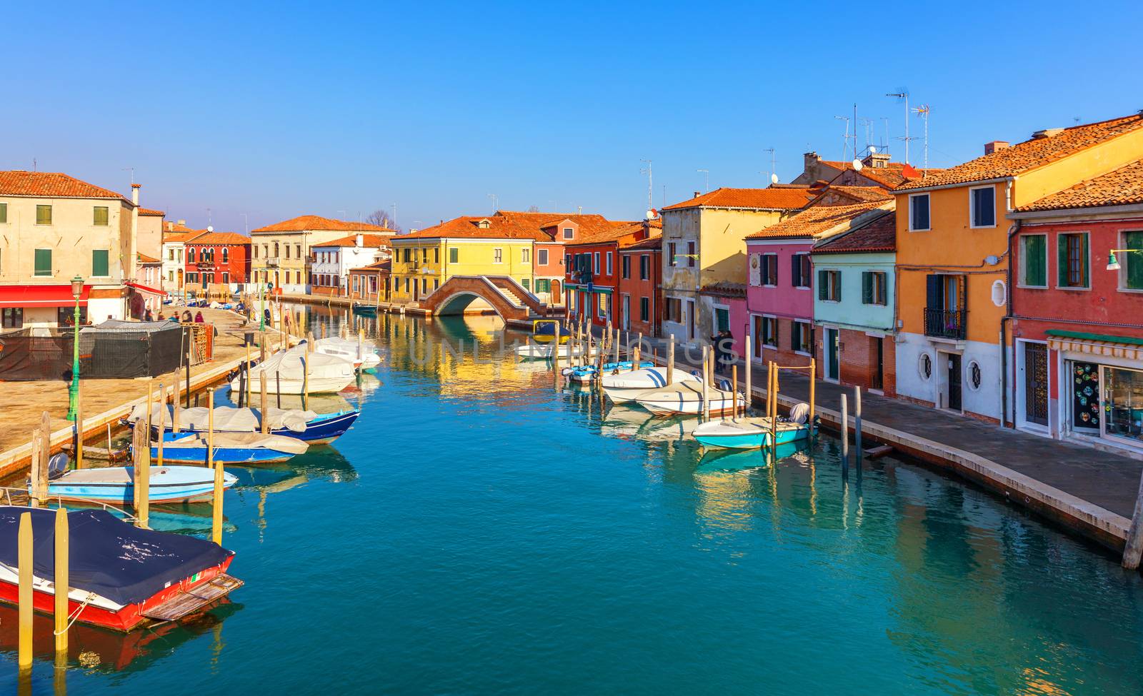 Street canal in Murano island, Venice. Narrow canal among old colorful brick houses in Murano, Venice. Murano postcard, Venice, Italy.