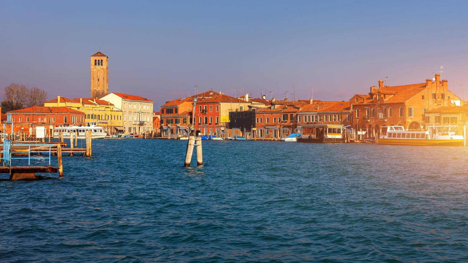 Street canal in Murano island, Venice. Narrow canal among old colorful brick houses in Murano, Venice. Murano postcard, Venice, Italy.