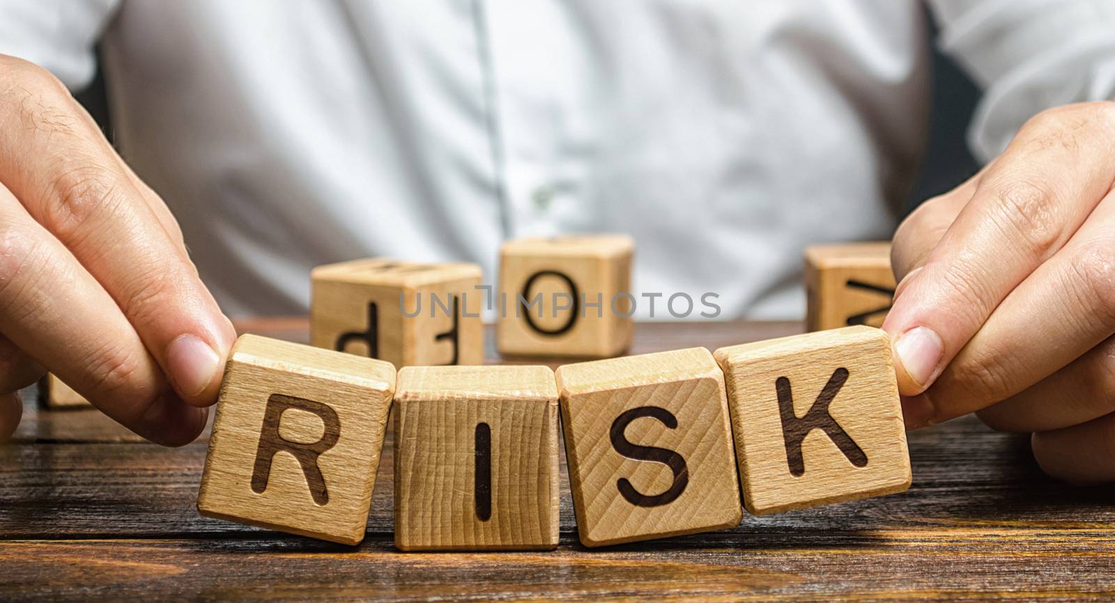 The man carelessly raises the word Risk. High risks in business, fragile balance and insecurity. Caution and anticipation of possible problems and shocks. Planning and action strategy. Analytics