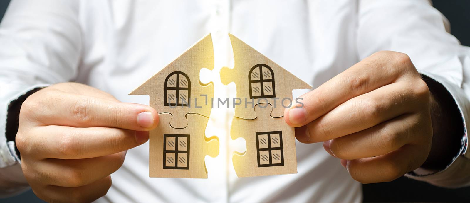 A man connects two puzzles into a whole house above the inscription Mortgage. Construction of your own residential building. Buying a home on credit loan, improvement of living conditions by iLixe48