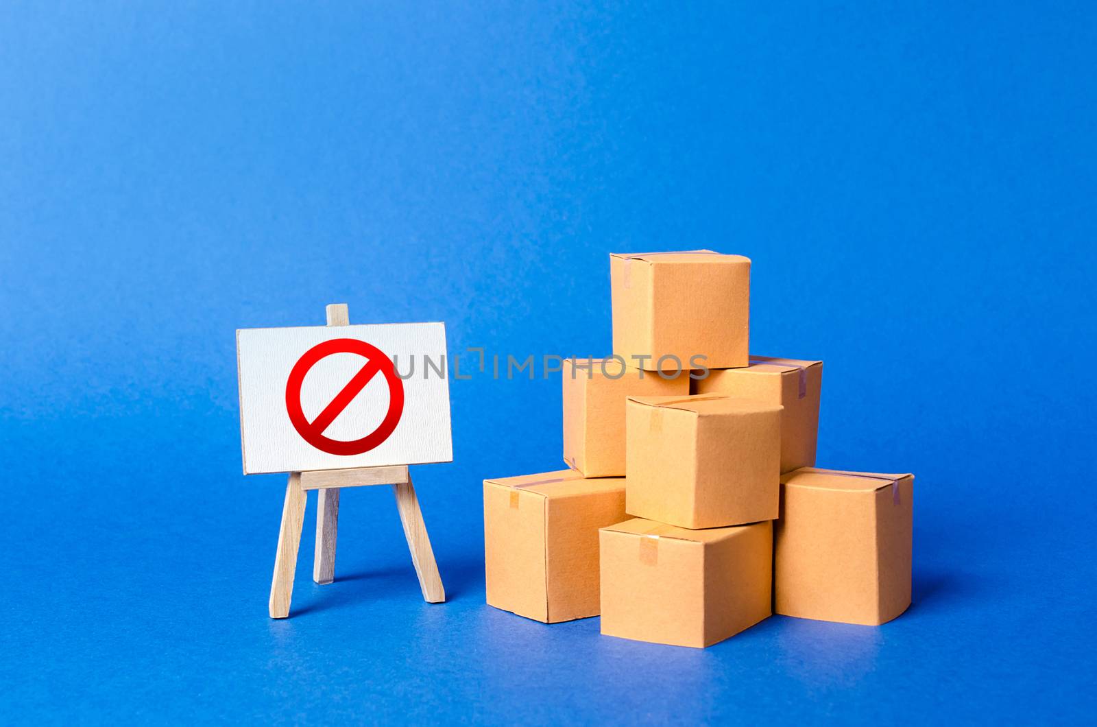 A stack pile cardboard boxes and a sign stand with red symbol NO. Restriction on the importation of goods, proprietary for business. Embargo, trade wars. Inability to sell products, ban on the import.