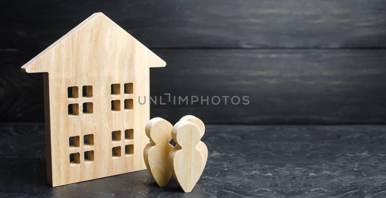 A group of people standing near the apartment building. Buying or selling housing and real estate. Lending to buy a house. Ownership Society. Affordable mortgage for young families. Rent or purchase