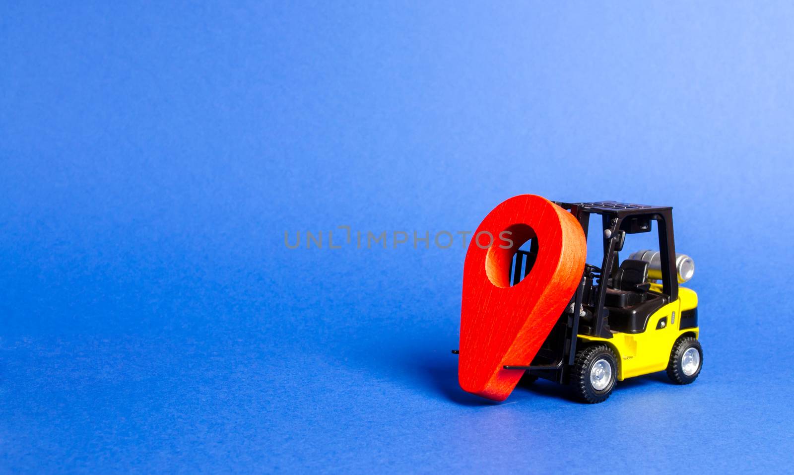 Yellow fork lift carries a red location pointer. Transportation services and logistics management in production warehouse. Destination cargo and parcels, tracking. Technological processes at factory