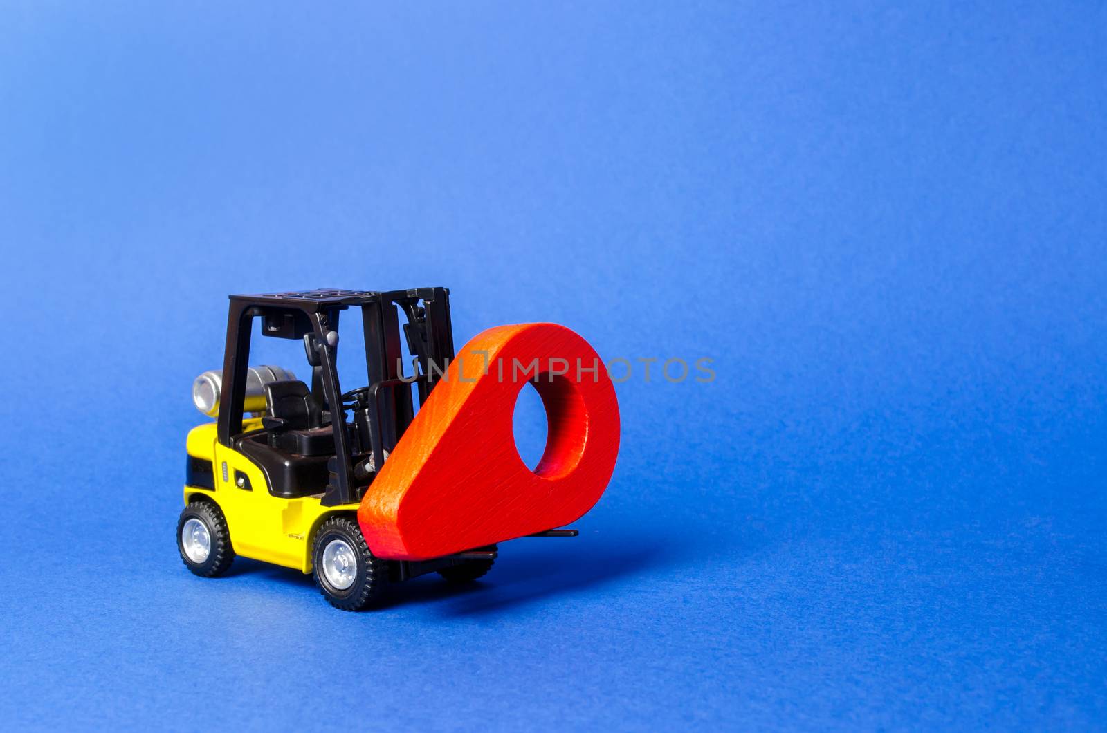 Yellow forklift carries a red location pointer. Destination cargo and parcels, tracking. Technological processes at factory. Transportation services and logistics management in production warehouse.