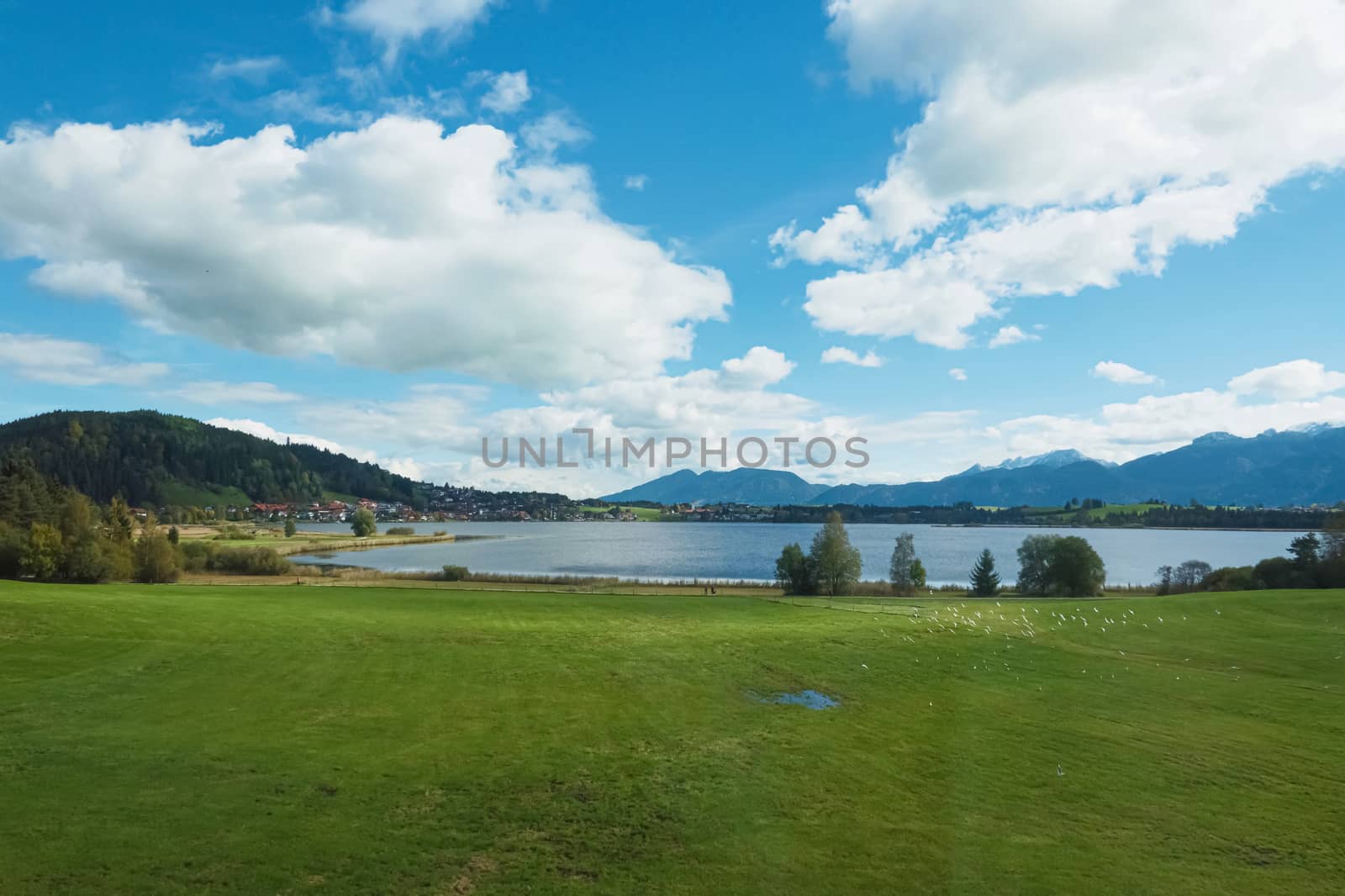 Beautiful nature of European Alps, landscape view of alpine mountains, lake and village on a sunny day, travel and destination scenery