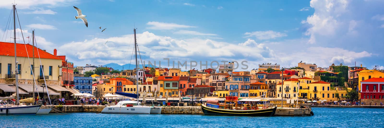 Old port of Chania with flying seagulls. Landmarks of Crete island. Bay of Chania at sunny summer day, Crete Greece. View of the old port of Chania, Crete, Greece. The port of chania, or Hania. 