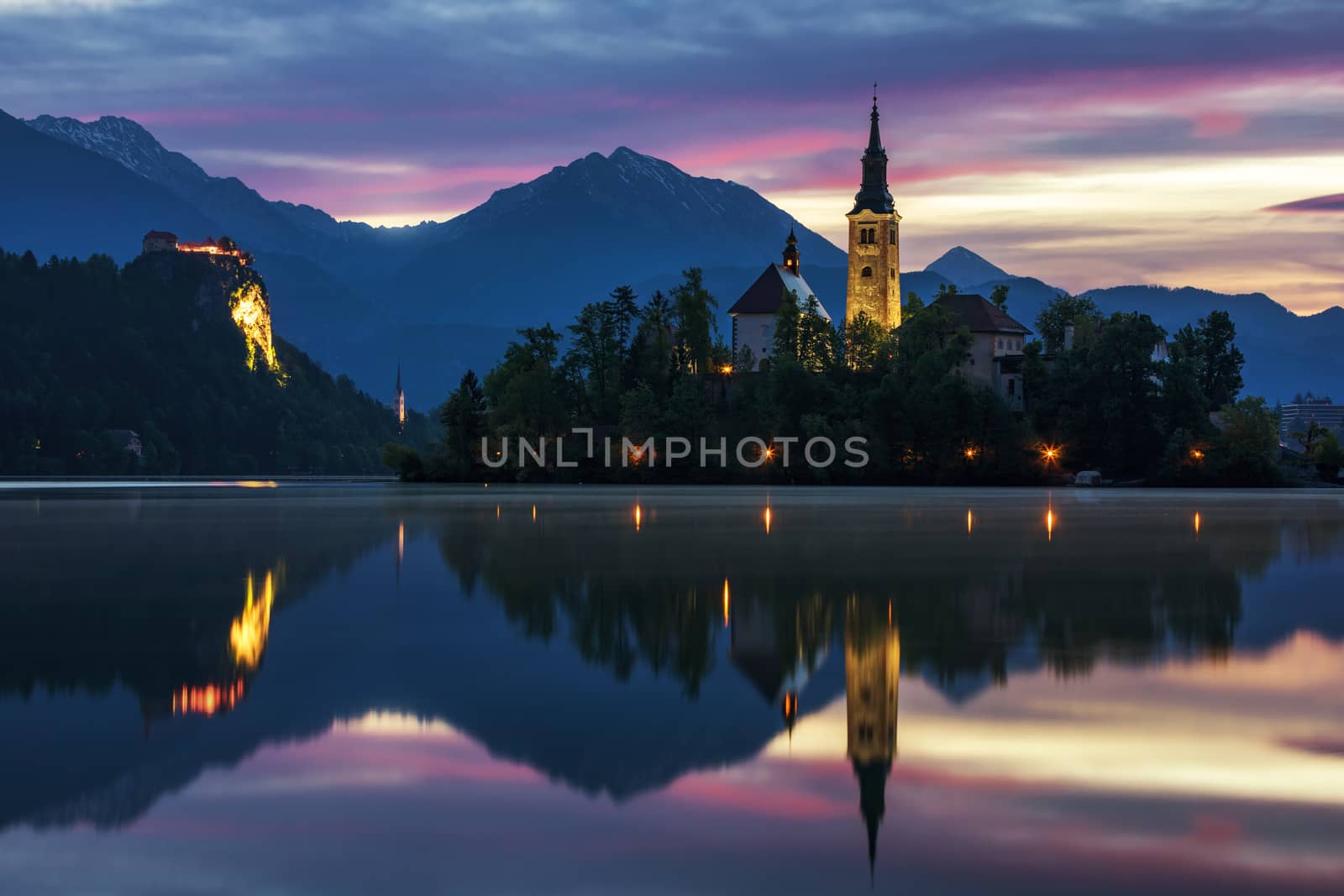 Dramatic sunrise on lake Bled, sunrise view on Bled lake, island, Pilgrimage Church of the Assumption of Maria and Castle with mountain range (Stol, Vrtaca, Begunjscica). Bled, Slovenia,