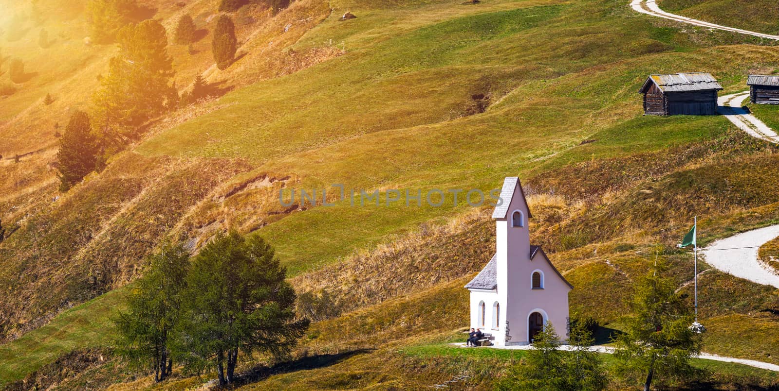 Chapel of San Maurizio at Passo Gardena, South Tyrol, Italy.  View to path to small white chapel San Maurizio and Dolomiti mountain. San Maurizio chapel on the Gardena Pass, South Tyrol, Italy.