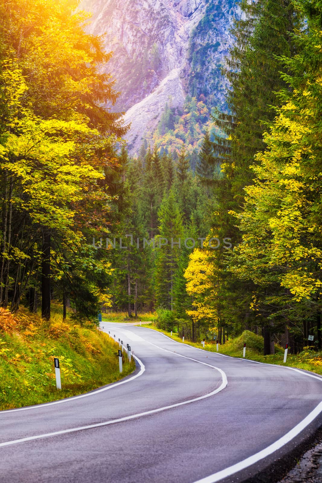 Mountain road. Landscape with rocks, sunny sky with clouds and beautiful asphalt road in the evening in summer. Vintage toning. Travel background. Highway in mountains.  