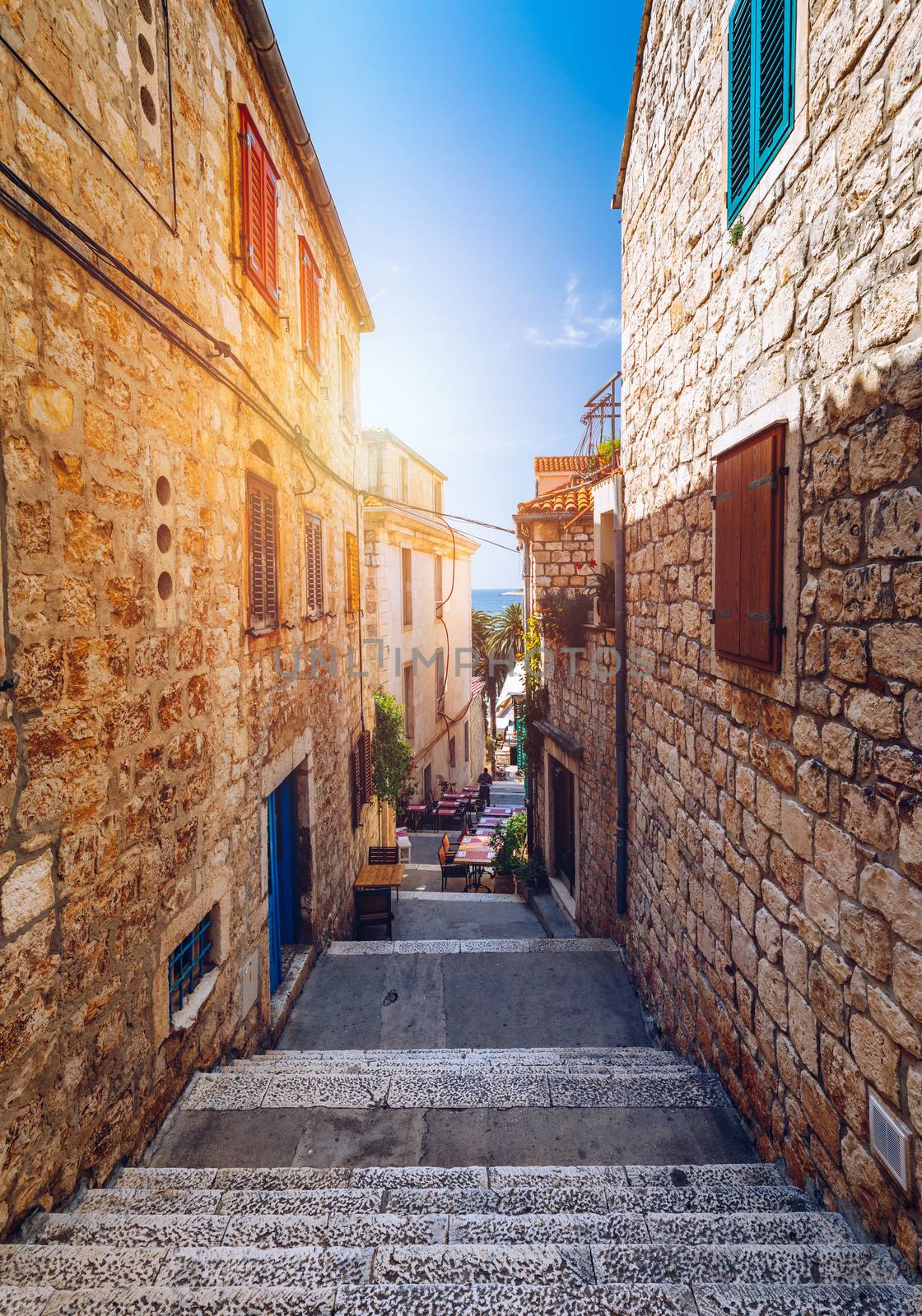 Beautiful street with flowers in the Hvar town, Hvar island, Dalmatia, Croatia. Old Mediterranean street, Hvar town. Old Adriatic town Hvar. Medieval street. Popular touristic destination of Croatia.