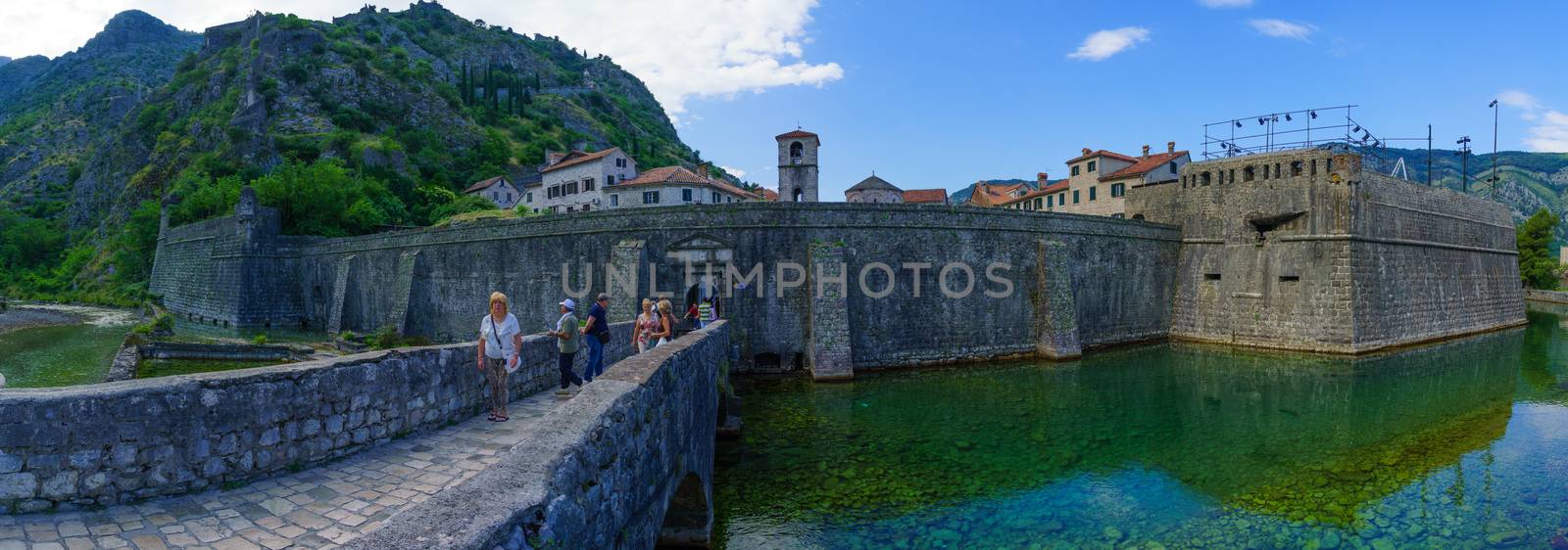 KOTOR, MONTENEGRO - JUNE 29, 2015: Panoramic view of The North Gate (River Gate), dated 1540, and the old town walls, with locals and tourists, in Kotor, Montenegro