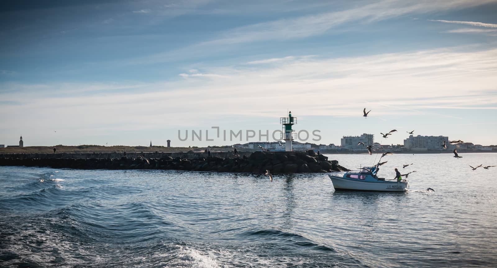 Small fishing boat entering the harbor accompanied by seagulls by AtlanticEUROSTOXX