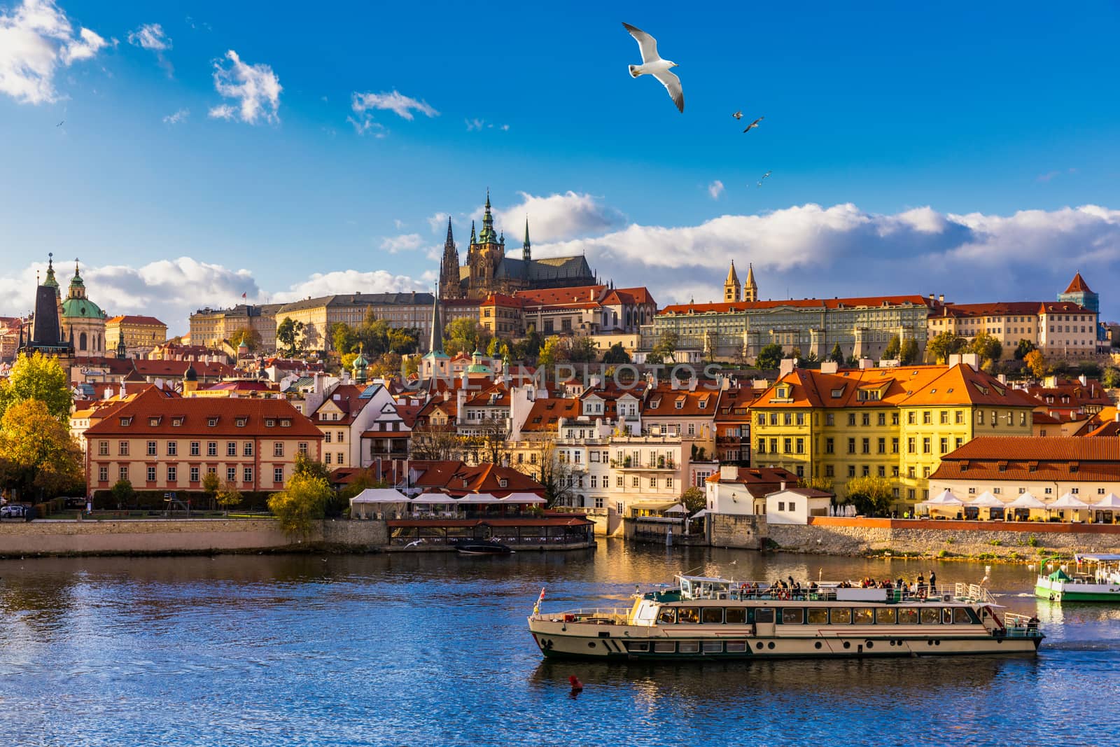 Prague Castle, Charles Bridge and boats on the Vltava river. View of Hradcany Prague Castle, Charles Bridge and a boats on the Vltava river in the capital of the Czechia. Boat cruise on Vltava river.