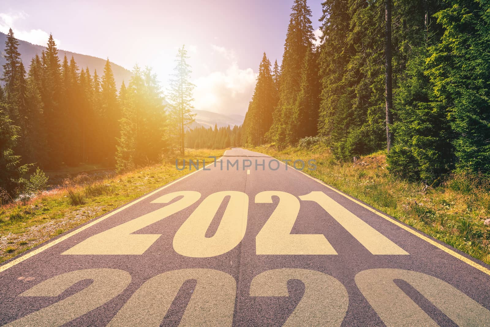 Empty asphalt road and New year 2021 concept. Driving on an empty road in the mountains to upcoming 2021 and leaving behind old 2020. Concept for success and passing time.