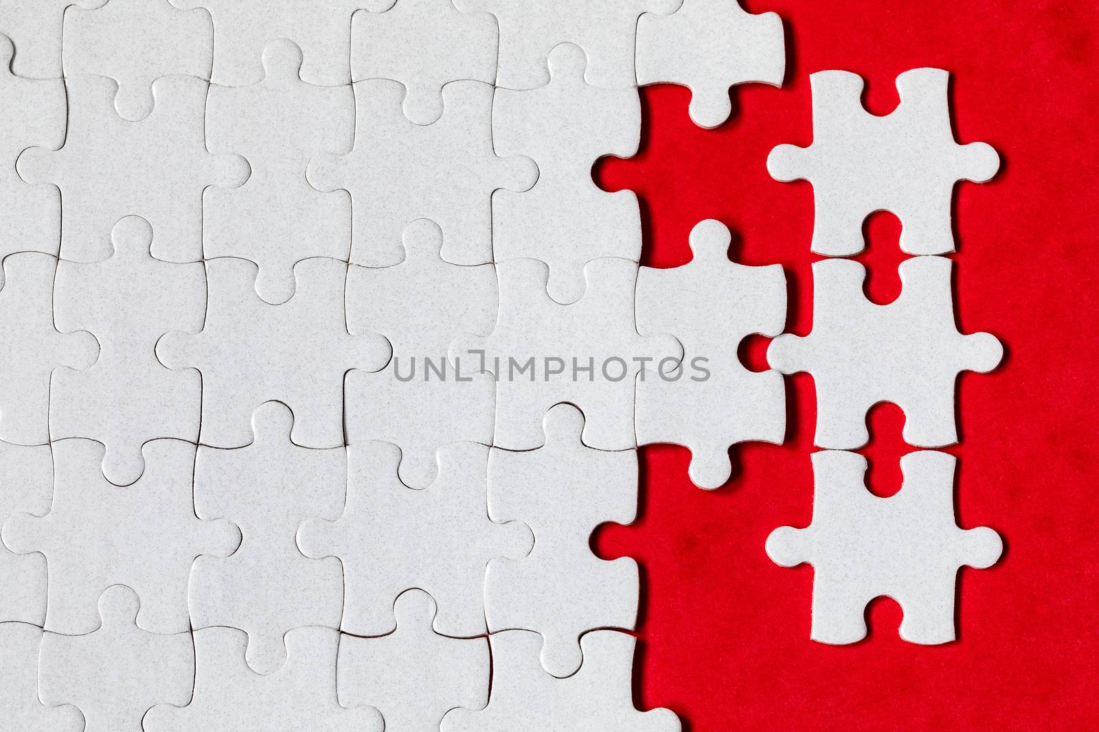 White jigsaw puzzle. White puzzle pieces on color background. Unfinished white jigsaw puzzle pieces on color background. 