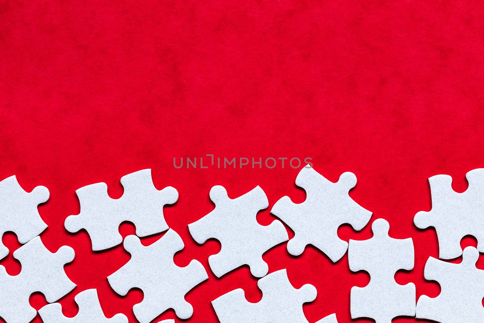White jigsaw puzzle. White puzzle pieces on color background. Unfinished white jigsaw puzzle pieces on color background. 