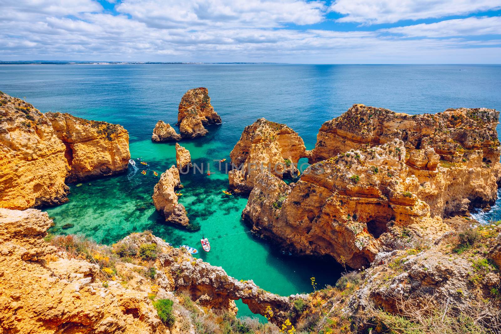 Panoramic view, Ponta da Piedade near Lagos in Algarve, Portugal. Cliff rocks and tourist boat on sea at Ponta da Piedade, Algarve region, Portugal. Ponta da Piedade, Algarve region, Portugal.
