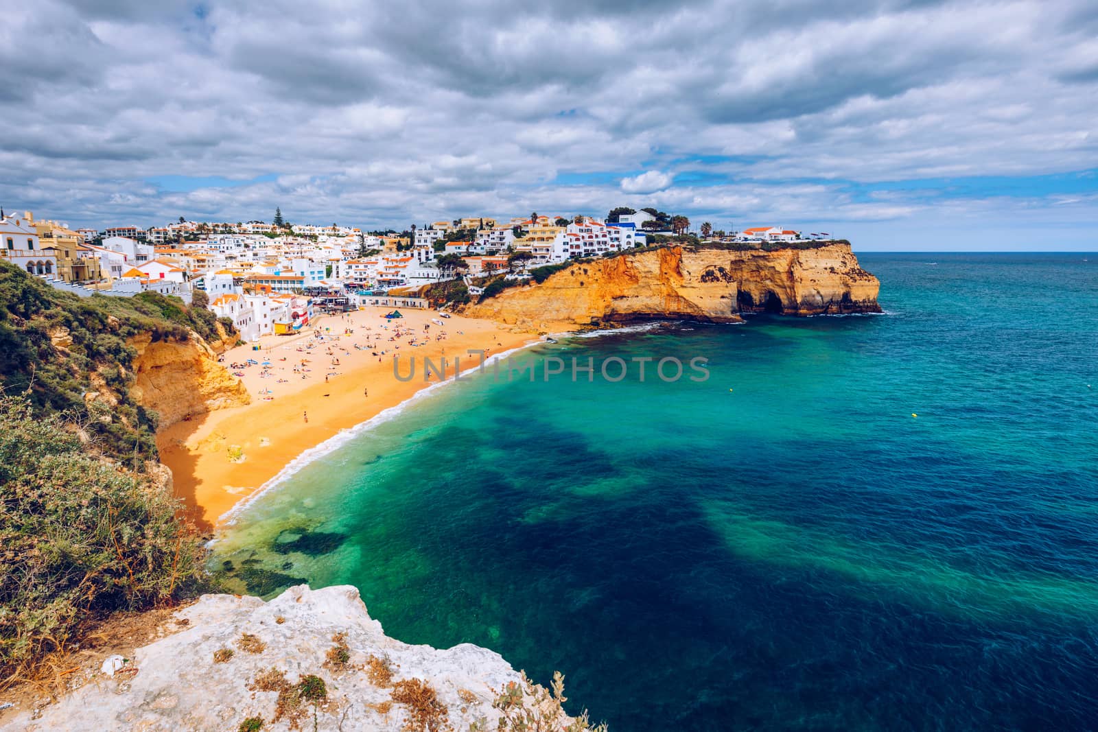 View of Carvoeiro fishing village with beautiful beach, Algarve, Portugal. View of beach in Carvoeiro town with colorful houses on coast of Portugal. The village Carvoeiro in the Algarve Portugal.