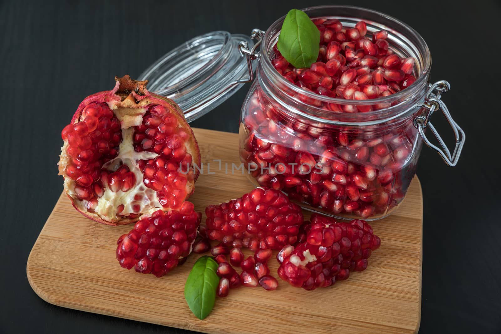 Ripe pomegranate fruit in a jar on wooden vintage background