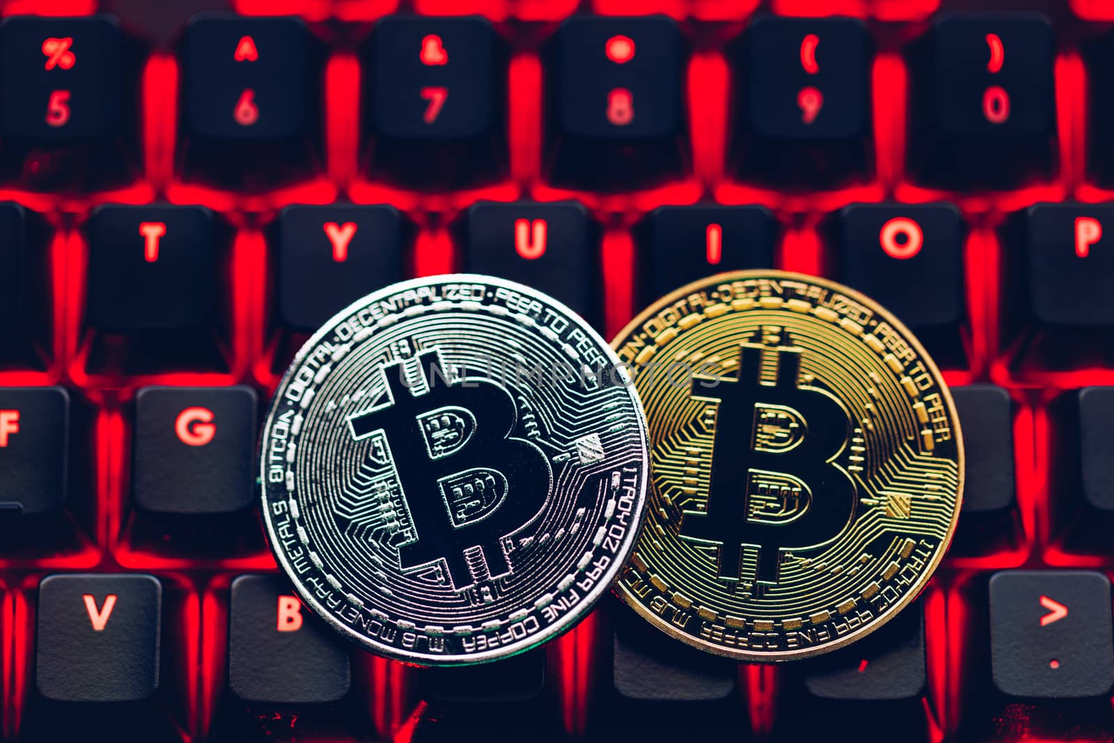 Bitcoin on compuer keyboard in background, symbol of electronic virtual money and mining cryptocurrency concept. Coin crypto currency bitcoin lies on the keyboard. Bitcoin on keyboard.