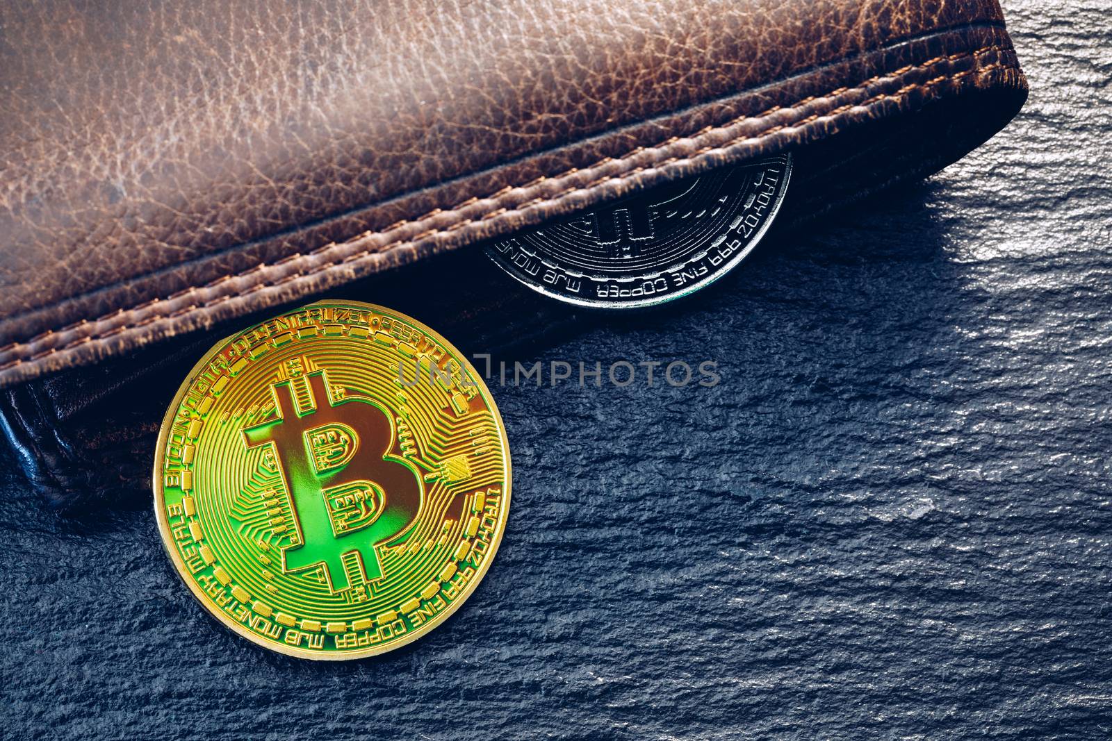 Bitcoin in brown leather wallet. Bitcoin, modern virtual cryptocurrency. Profit from mining crypto currencies. Bitcoin gold coins with wallet, close-up. Virtual cryptocurrency concept.