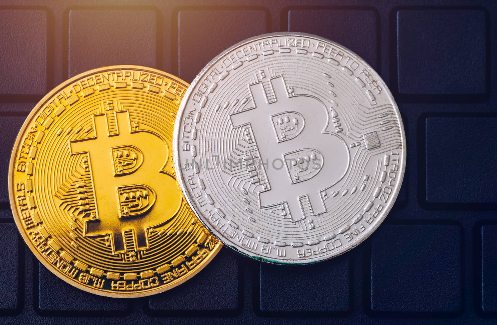 Bitcoin on compuer keyboard in background, symbol of electronic virtual money and mining cryptocurrency concept. Coin crypto currency bitcoin lies on the keyboard. Bitcoin on keyboard.