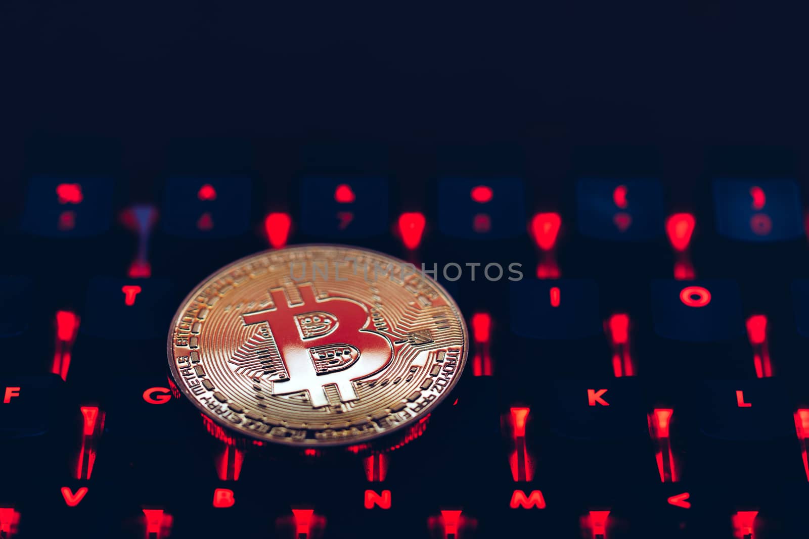 Bitcoin on compuer keyboard in background, symbol of electronic virtual money and mining cryptocurrency concept. Coin crypto currency bitcoin lies on the keyboard. Bitcoin on keyboard.