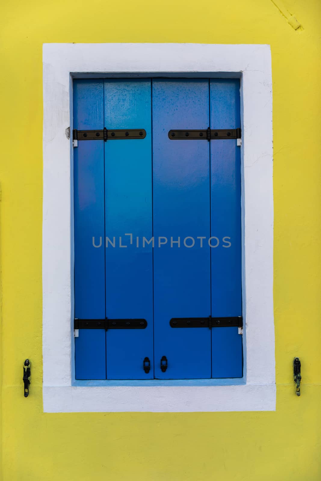 Colorful window of a house on the Venetian island of Burano, Venice. Facade of the houses of Burano close-up. Venice, Italy.