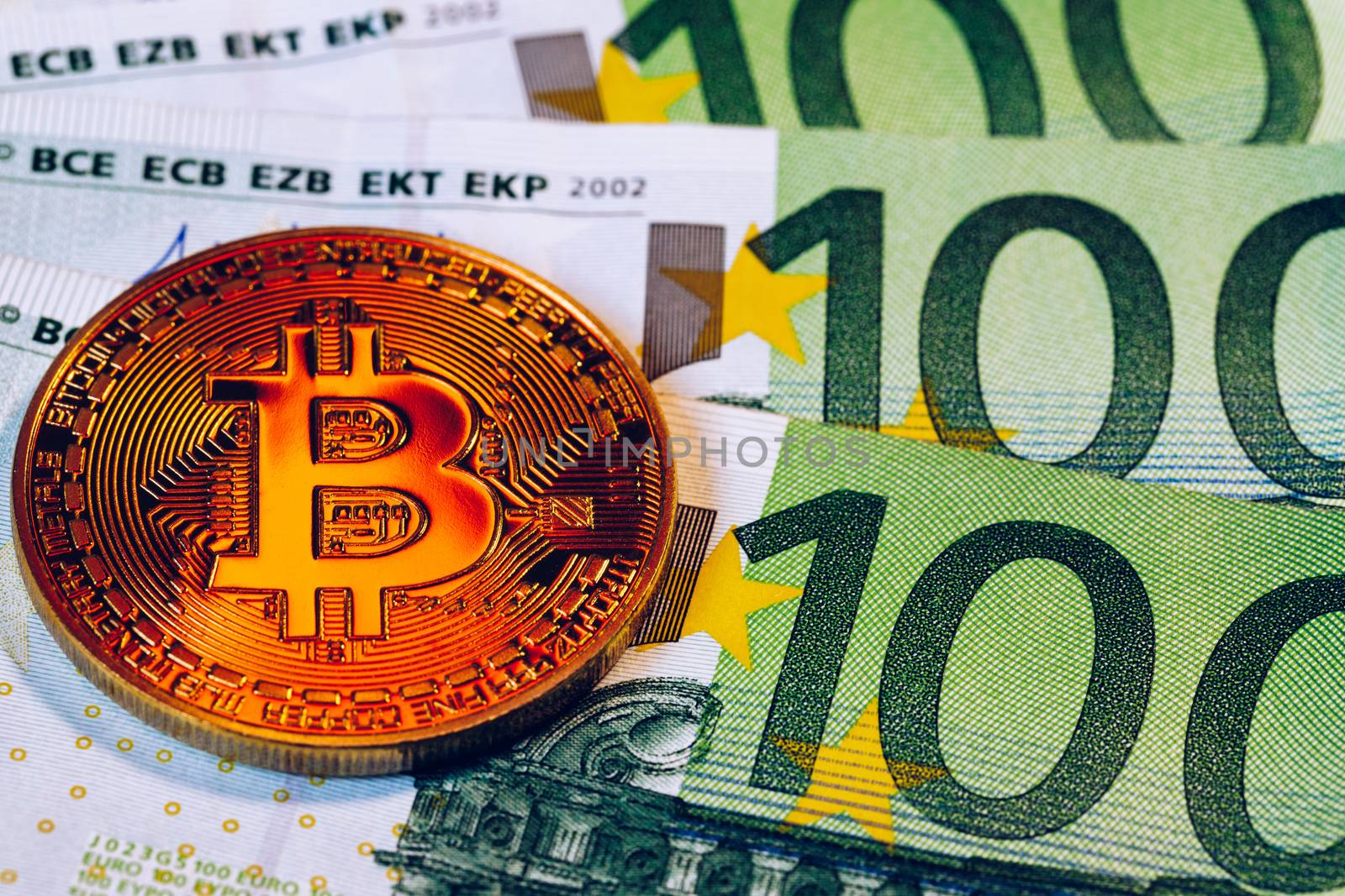 Golden bitcoin over Euro money. Bitcoin cryptocurrency. Crypto currency concept. Bitcoin with euro bills. Bitcoins stacked on euro banknotes.