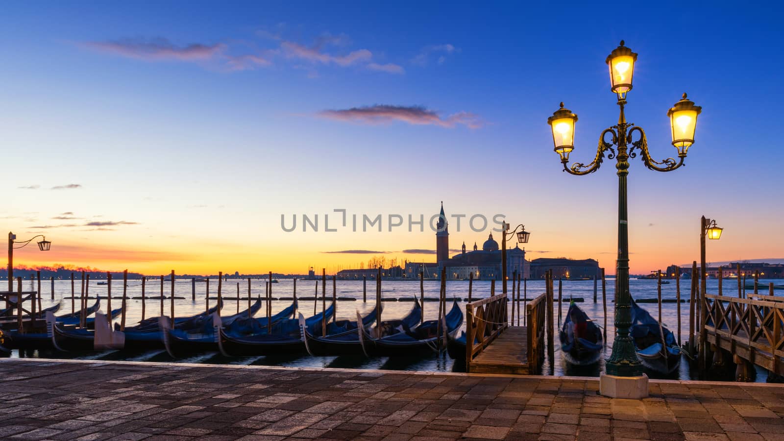 Scenic view of San Giorgio Maggiore, gondolas and lamp at colorful sunrise, Venice, Italy. Sunset in Venice. Gondolas at Saint Mark's Square and church of San Giorgio Maggiore on background, Italy, Europe