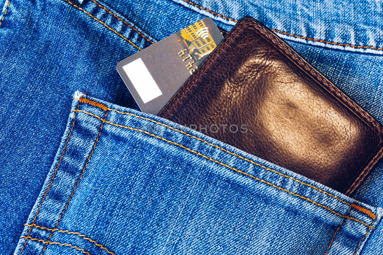 Credit card in wallet in pocket of jeans, closeup. Closeup of wallet and credit card in jeans trousers pocket. 