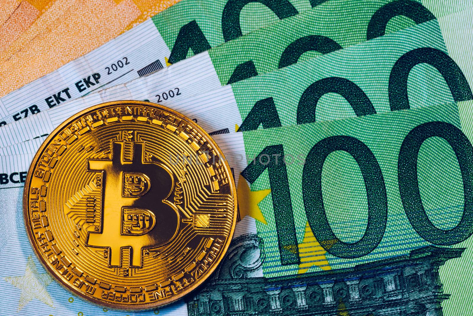 Golden bitcoin over Euro money. Bitcoin cryptocurrency. Crypto currency concept. Bitcoin with euro bills. Bitcoins stacked on euro banknotes.