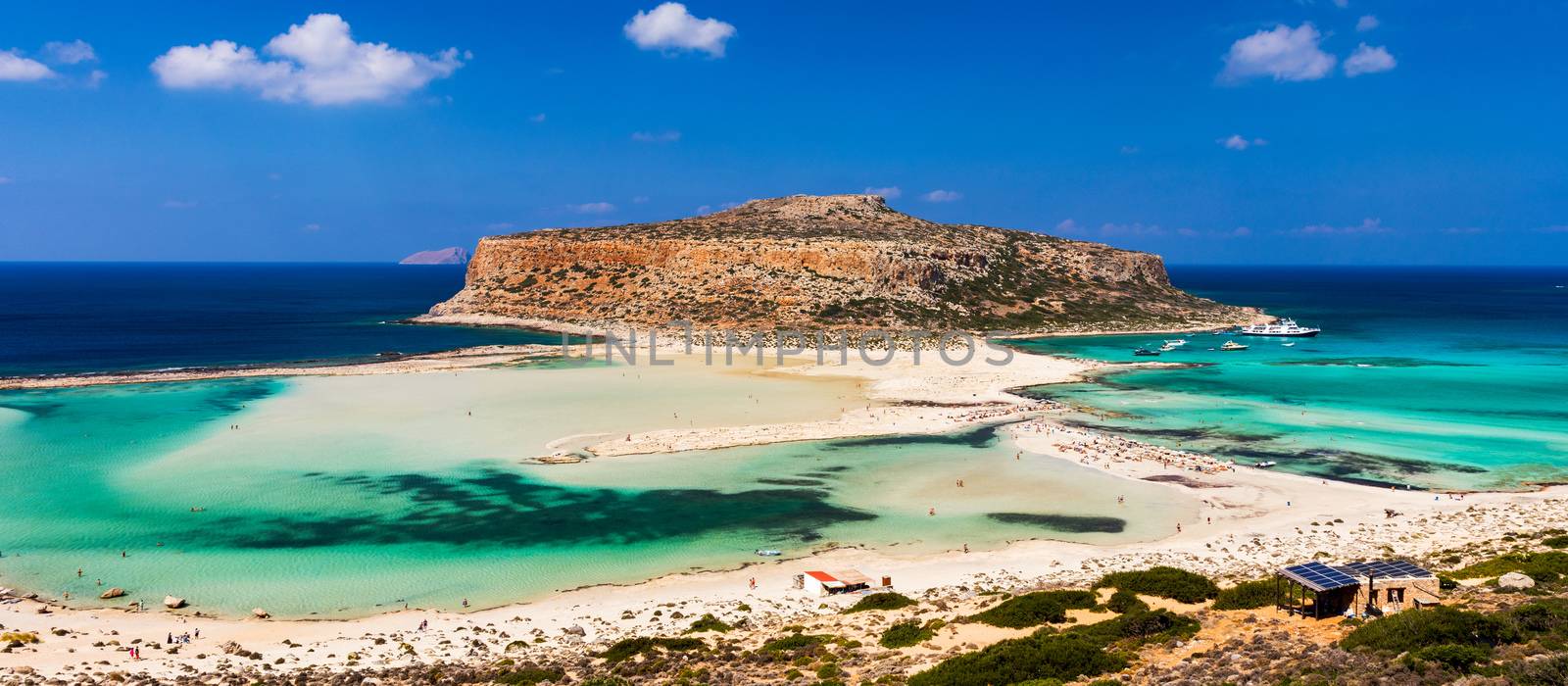 Fantastic panorama of Balos Lagoon and Gramvousa island on Crete, Greece. Cap tigani in the center. Balos beach on Crete island, Greece. Tourists relax and bath in crystal clear water of Balos beach.