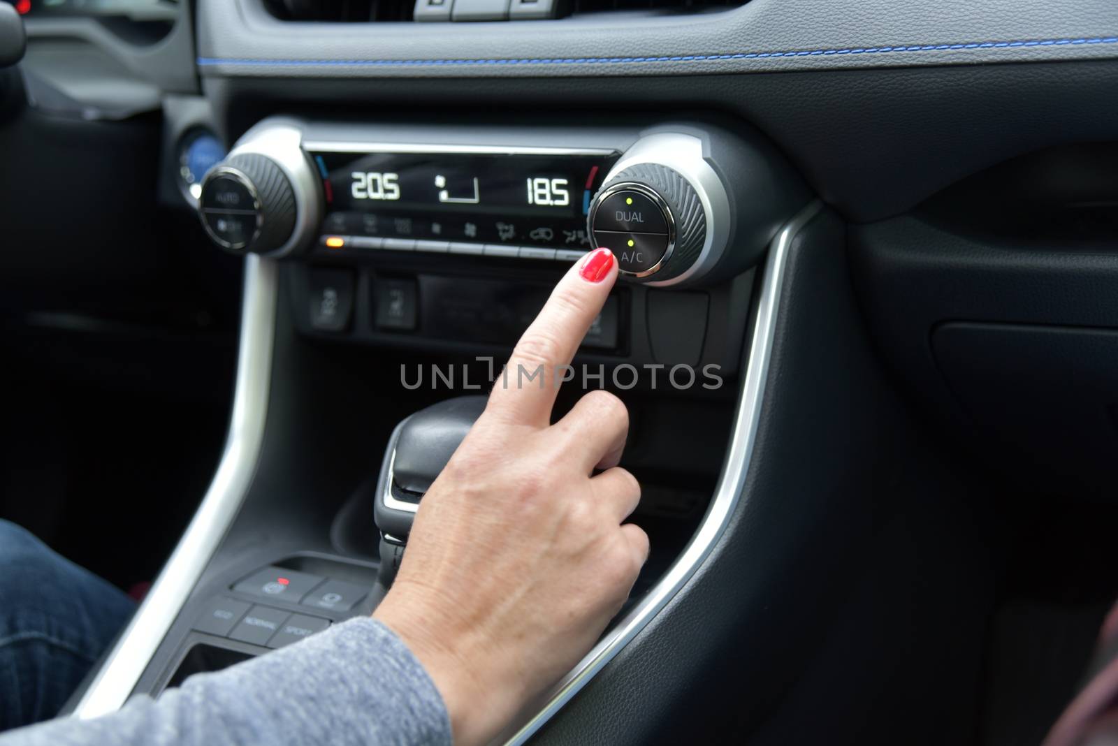 Close up of woman hand pressing turn on air-conditioner button a car by aselsa