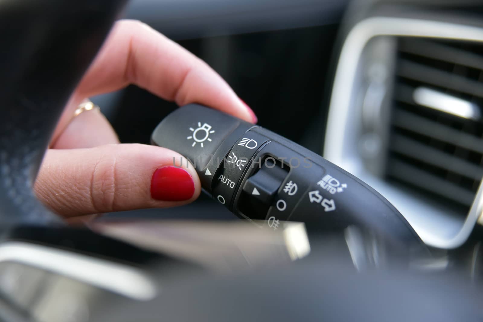 Female finger on the button to activate car lighting by aselsa