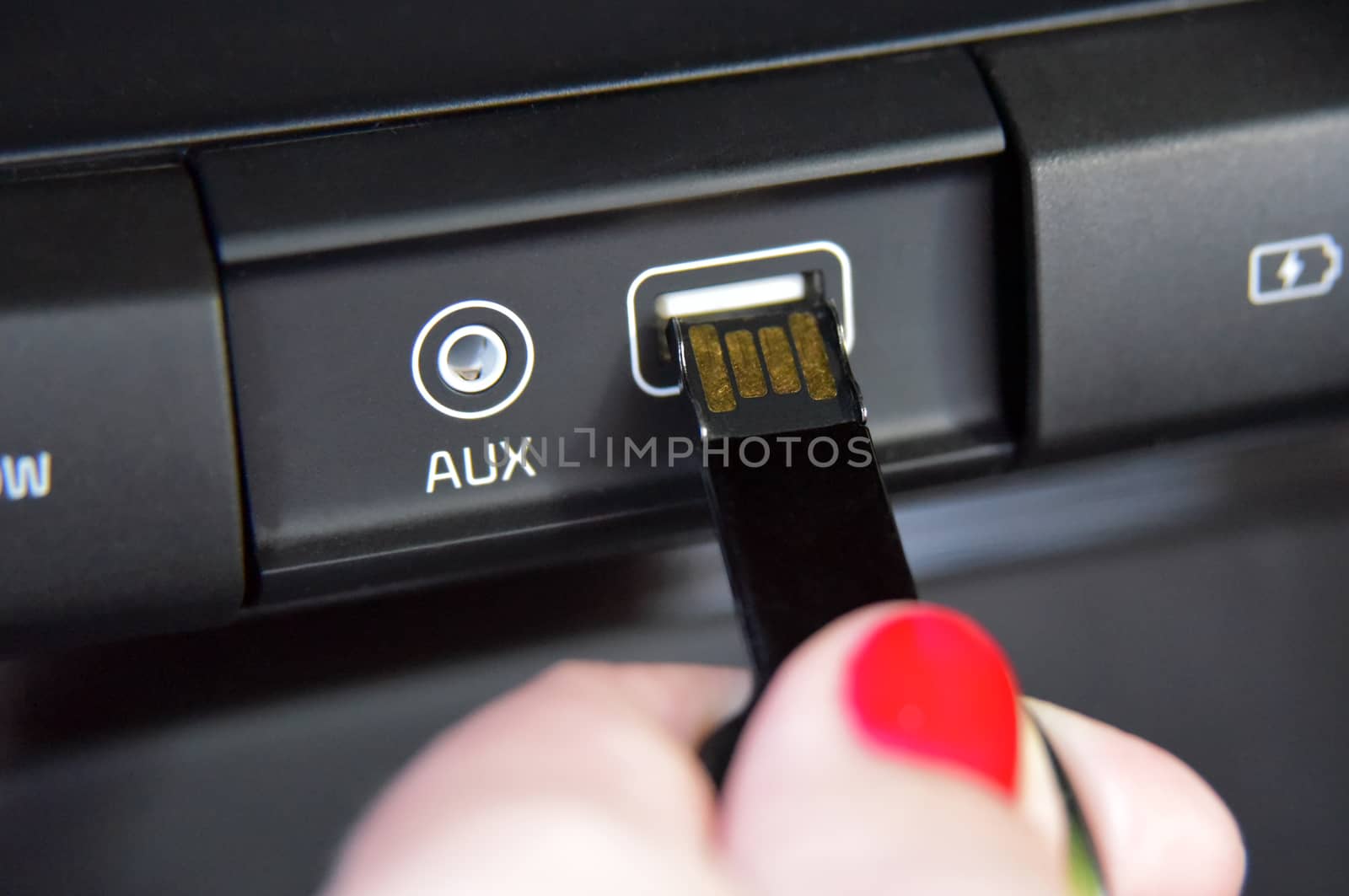 female fingers insert USB memory into usb port on car dashboard by aselsa