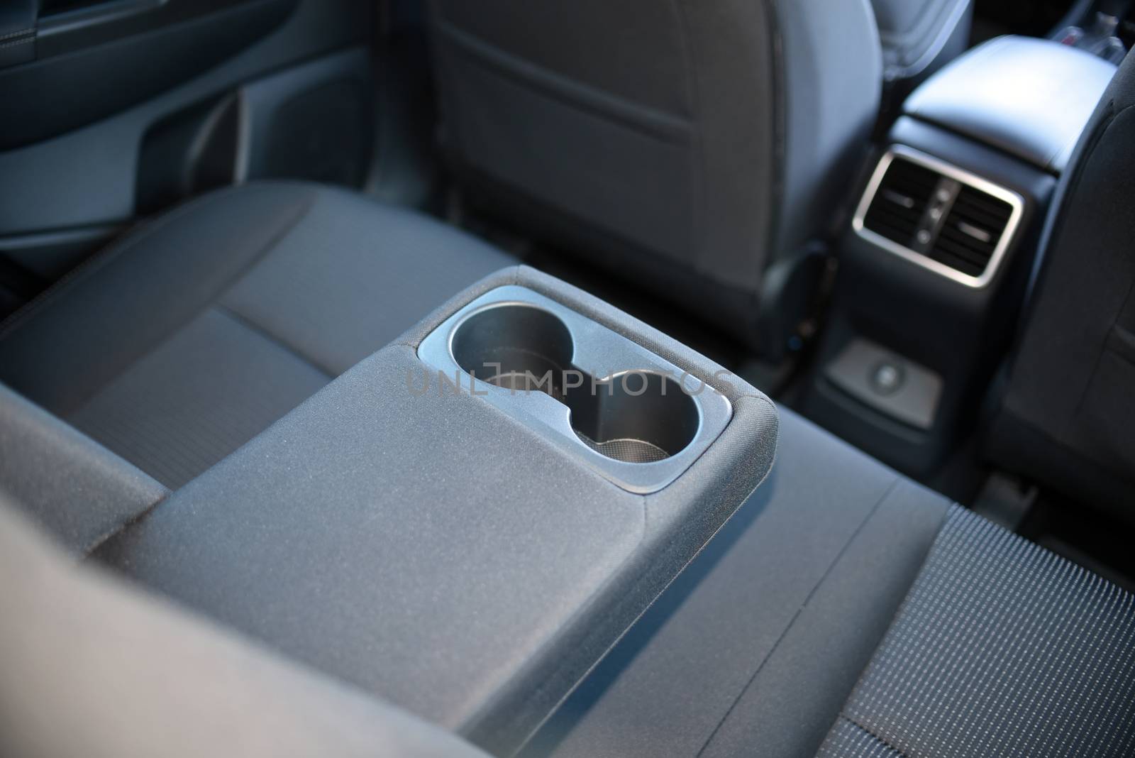 armrest in the luxury passenger car with cup holder between the front seats