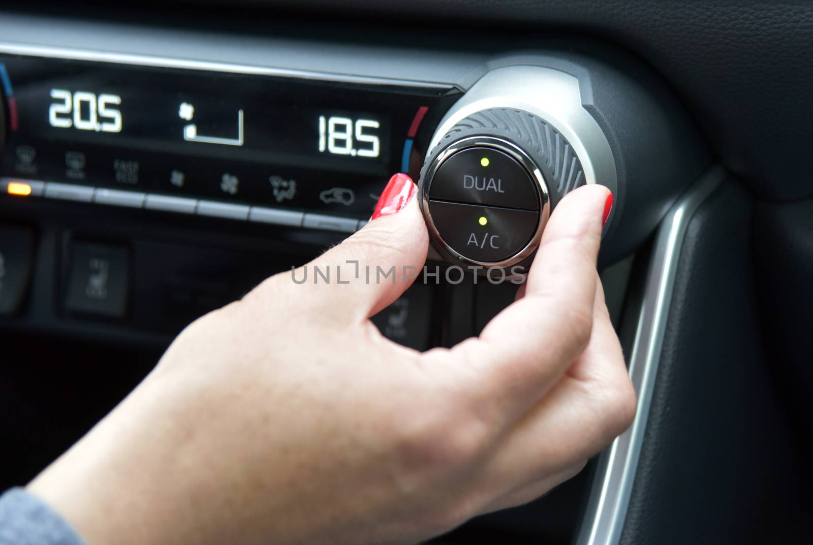 Close up of woman hand pressing turn on air-conditioner button a car by aselsa