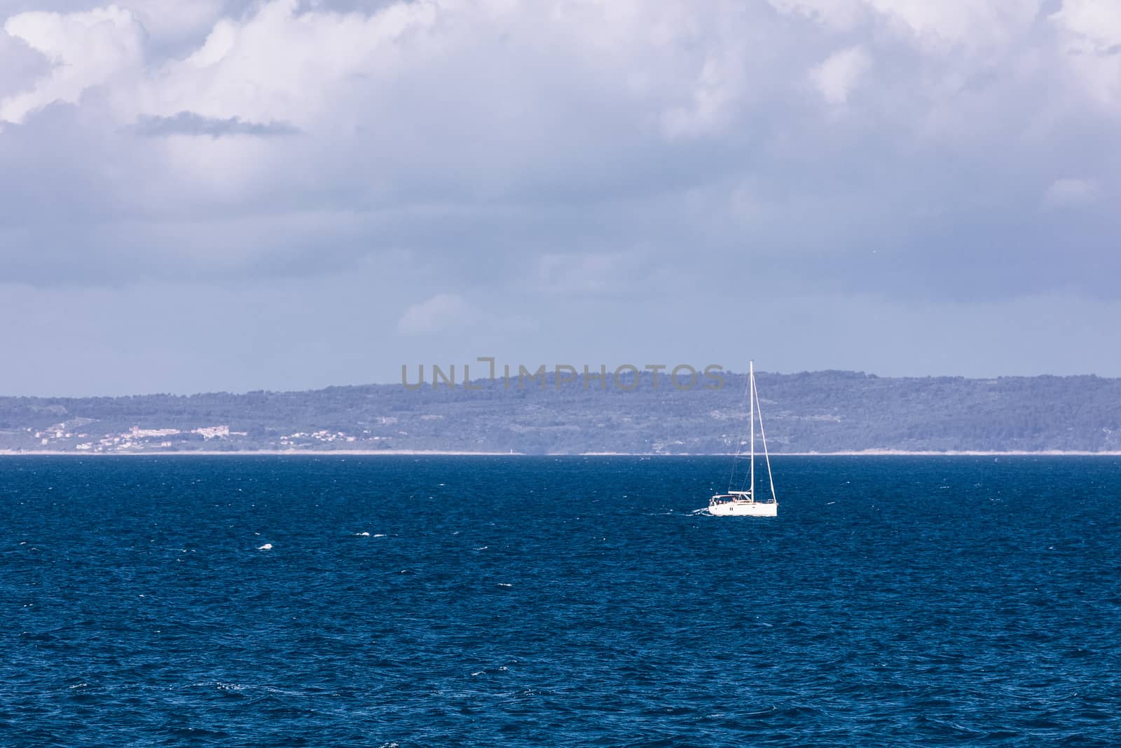 Sailboat in the sea in the evening sunlight with mountains background, luxury summer adventure, active vacation in Mediterranean sea, Croatia. Sailing ship luxury yacht with white sails in the Sea. 