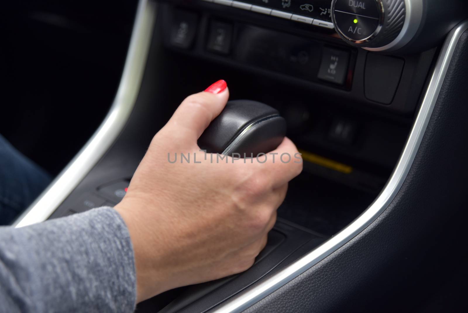 a woman's hand holds an automatic transmission lever in the car by aselsa
