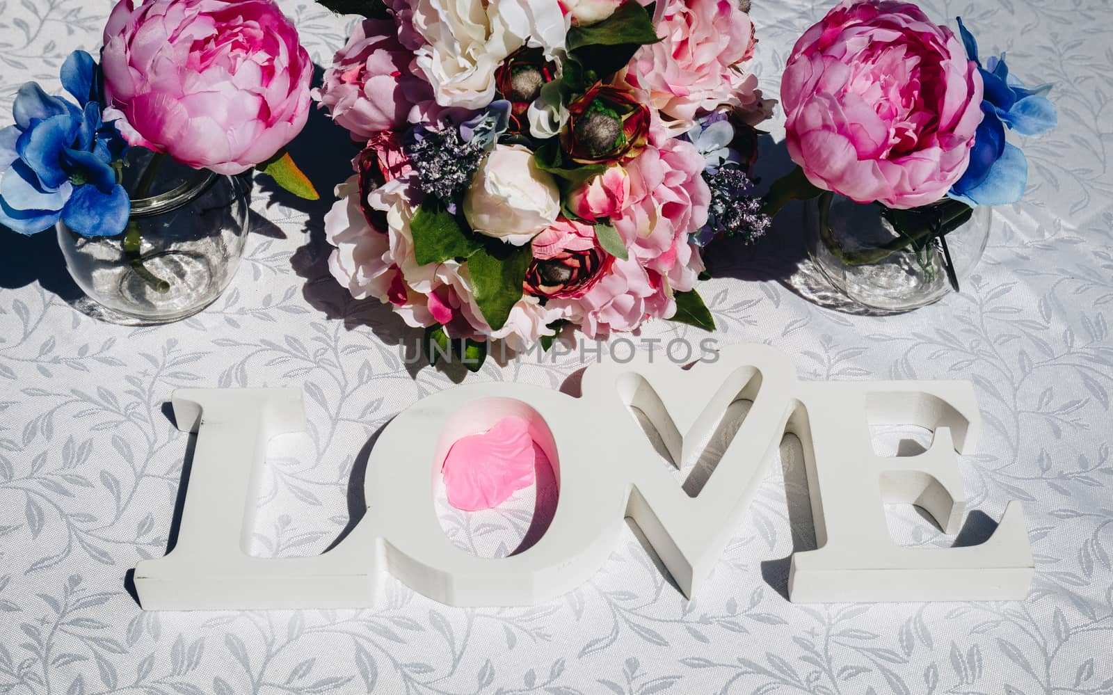 Creative layout with colorful flowers, leaves and Word LOVE. Love concept.