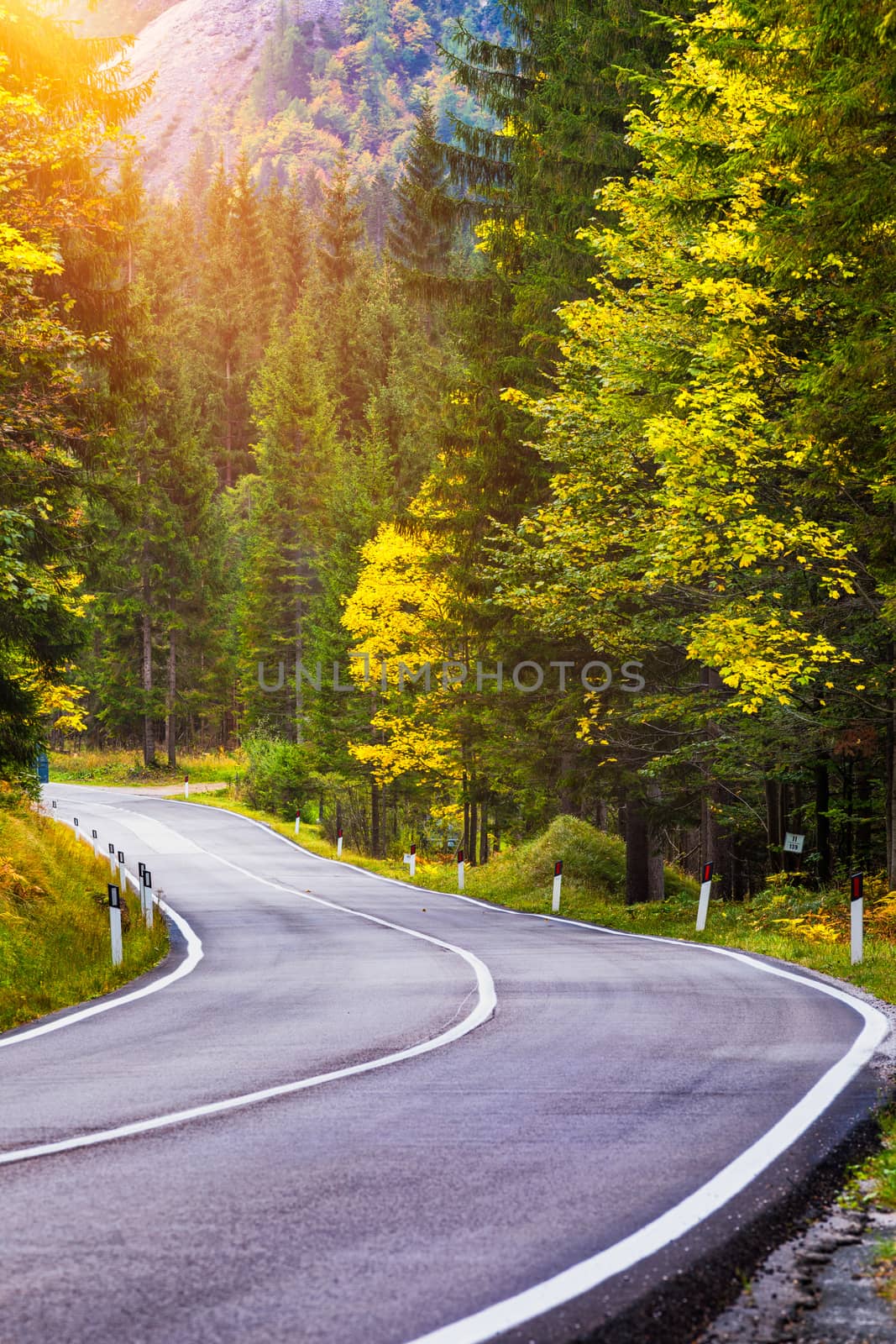 Mountain road. Landscape with rocks, sunny sky with clouds and beautiful asphalt road in the evening in summer. Vintage toning. Travel background. Highway in mountains.  